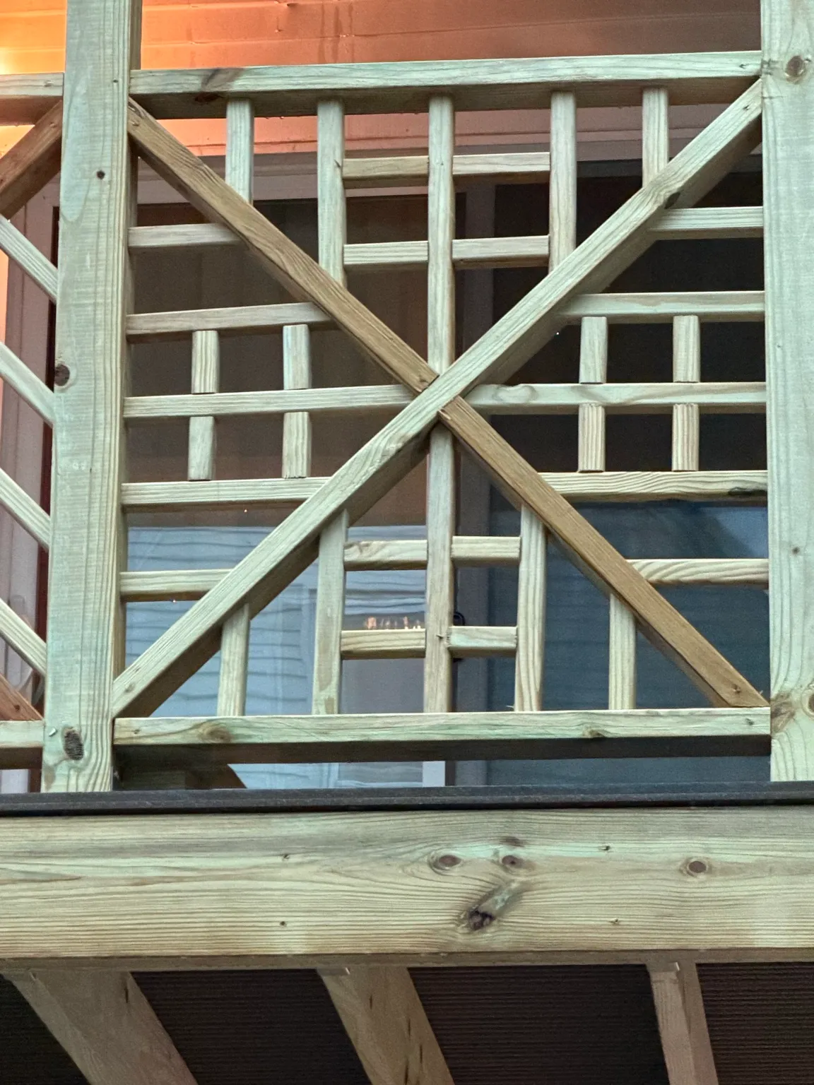 Close view of new exterior wood railing and cross-brace carpentry