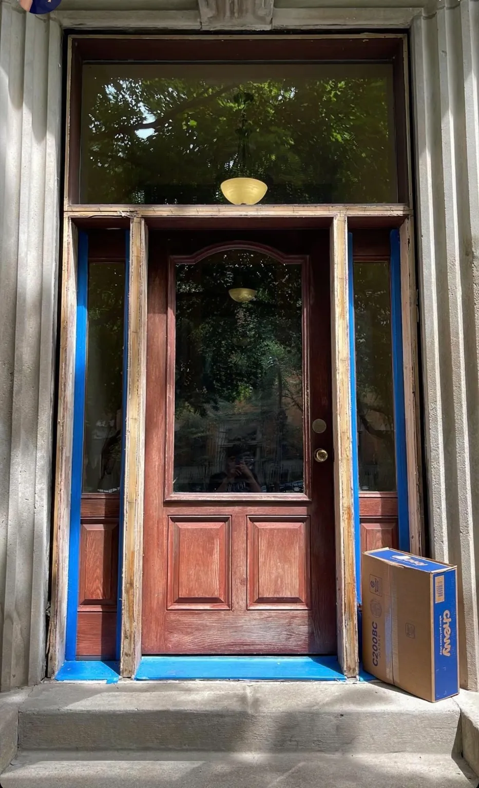 Wood entry door and sidelights being prepared for refinishing
